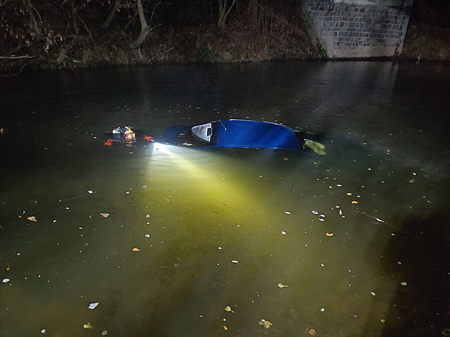 Auto po nehodě skončilo v řece, zasahující hasiče potrápil terén i únik oleje